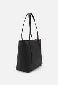 Black tote bag with two long handles, rectangular shape, textured surface, and contrasting interior color. Simple design, no visible hardware.
