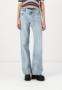 Light blue wide-leg jeans made of denim, featuring a classic five-pocket design and subtle whiskering on the front.
