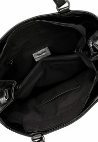 Intérieur de sac à main noir avec tissu lisse, plusieurs poches, un compartiment zippé et une étiquette de marque. Ouverture large avec une forme structurée.