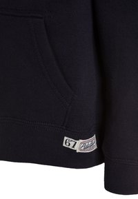 Sweatshirt bleu marine avec une poche frontale, des poignets et un ourlet côtelés. Présente un écusson en tissu avec "67" et le logo de la marque sur le bas à gauche.