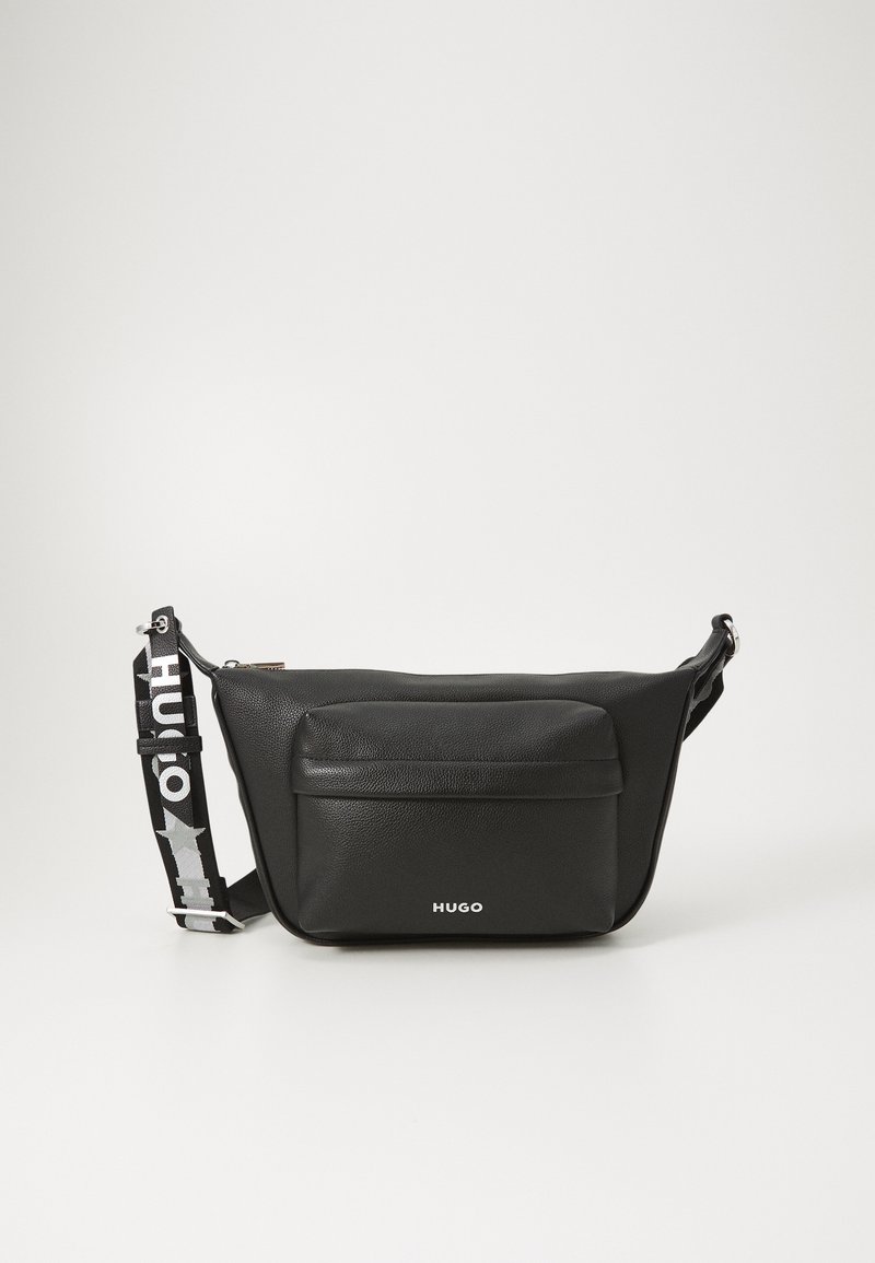 Svart lær crossbody-veske med en frontlomme, justerbar stropp med logo og en jevn tekstur; kompakt rektangulær form.