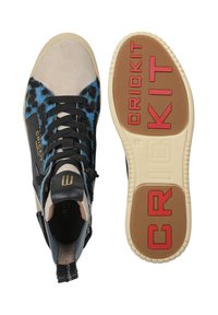 High-top sneaker with blue leopard print accents, beige suede and black leather panels, black laces, and textured rubber sole labeled "CRICKIT."