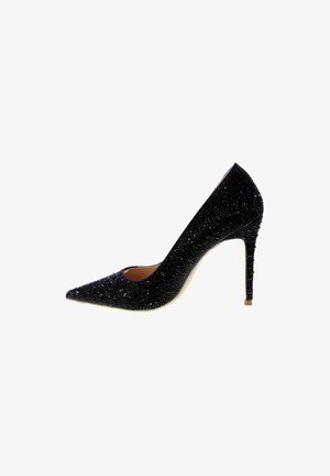 Sort højhælet sko med spids tå, dækket af tekstureret glitrende materiale, med en slank stiletto hæl og en udskæring i siden.