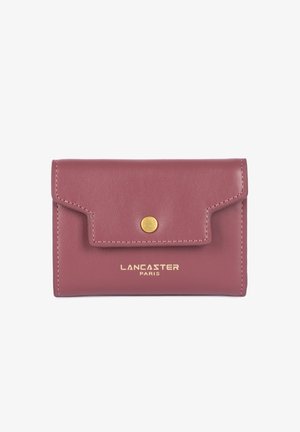 Compact rose-colored leather wallet with a flap, gold snap closure, and embossed logo. Features minimalist design and visible stitching accents.