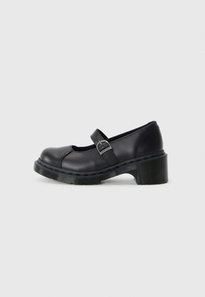 Black leather Mary Jane shoes with a rounded toe, adjustable strap, and a medium block heel. Features contrast stitching and a textured sole.