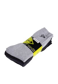 Grijze en zwarte sportsokken met ribbeltextuur, elastische boorden en een label met logo en maatvoering, verpakt in een gele en zwarte wikkel.