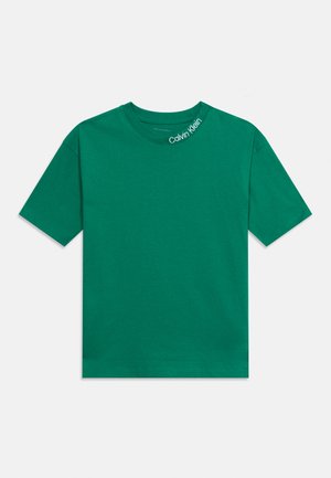 Green short-sleeve crewneck t-shirt with white "Calvin Klein" text on the collar, laid flat on a white background.
