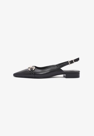 Scarpa slingback in pelle nera con punta affusolata, tacco piatto e un elegante accessorio in argento decorativo sul davanti. Texture liscia, design minimalista.