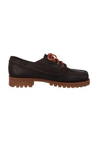 Zapato de cuero marrón con suela robusta, que presenta cordones y costuras marrones. El cuerpo principal tiene una textura suave y un diseño de punta redondeada.