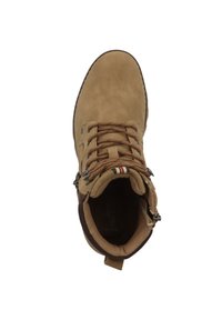 Bota de senderismo de ante marrón con cordones, suela de goma y un collarín acolchado. Presenta costuras decorativas y una lengüeta en la parte trasera.