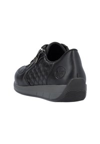 Zapato de cuero negro con textura acolchada, cierre de cremallera y suela de goma gris. Presenta el logo en el lateral y un tacón redondeado para mayor estabilidad.