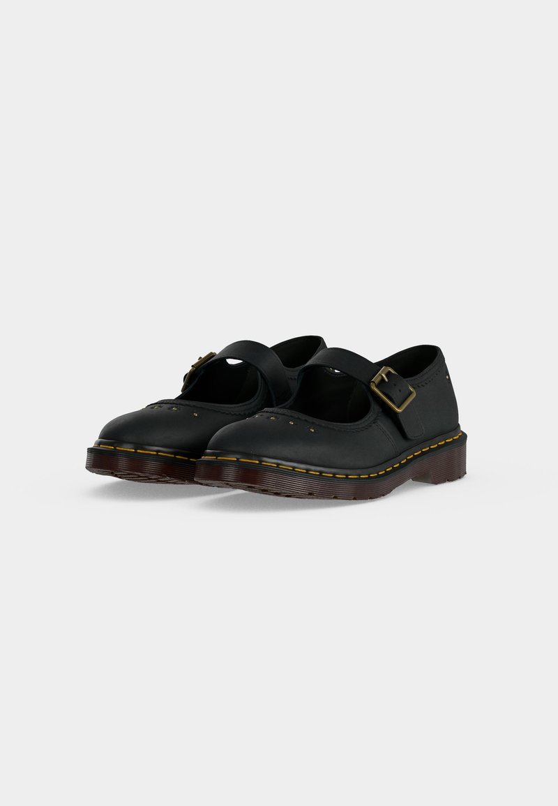 Coppia di scarpe Mary Jane nere in pelle con cinturino e fibbia, cuciture gialle e suole spesse in gomma marrone su sfondo bianco.