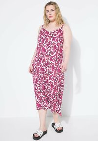 Abito maxi floreale in rosa e bianco con spalline sottili e vestibilità rilassata, abbinato a sandali platform neri.