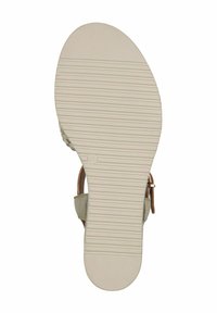 Suola di sandalo beige con superficie in gomma testurizzata, dotata di scanalature orizzontali per la trazione e una forma curvata, senza decorazioni visibili.