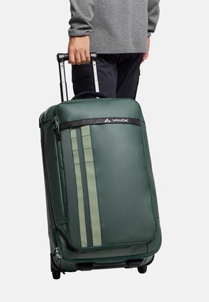 Valigia a rotelle realizzata in materiale sintetico verde, con una superficie liscia, dettagli a righe verticali e una maniglia superiore nera con ruote.