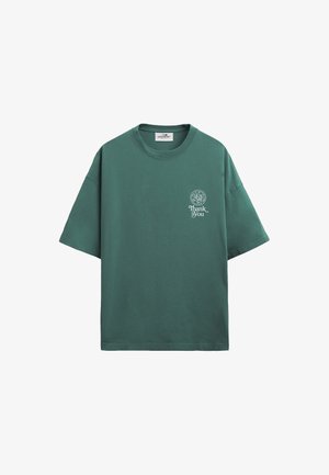 Zöld, túlméretezett, rövid ujjú póló kerek nyakkal, bal mellrészen egy kis fehér "Thank You" felirattal és kör alakú logóval.