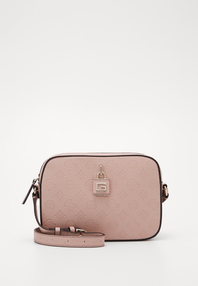 Obdélníková růžová crossbody kabelka s embosovaným monogramem, zlatým visacím zámkem na přední straně a nastavitelným popruhem položeným vpředu.