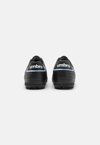 Black soccer cleats with a textured design, featuring white "umbro" branding and a blue accent along the heel. Lightweight construction.