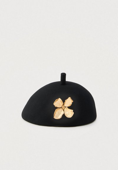 Mustast feltist barett ümara kujuga, millel on külje peal tekstuurse kuldse lilledekoor ja väike kergitatud tipp.