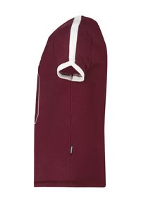 T-shirt corto marrone con maniche a sbuffo e striscia verticale bianca sulla manica, con un piccolo etichetta nera con la scritta "AMERICA" sul lato.