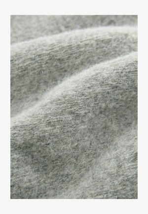 Tissu gris clair avec une texture douce et duveteuse, présentant un motif tissé et un léger contraste, disposé en ondulations douces.