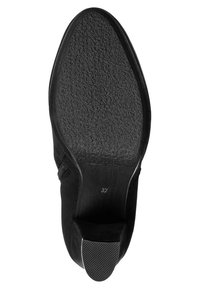 Semelle de chaussure noire avec surface en caoutchouc texturé, forme arrondie et étiquette de taille "37" sur la semelle intérieure. Bords lisses et accent de talon proéminent.