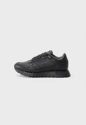 Black low-top sneaker with textured sole, lace-up front, and padded collar, shown in right side profile on white background.