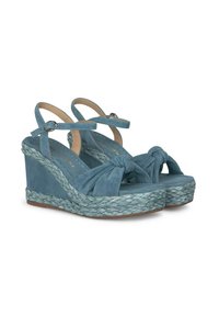 Sandales à wedges en suede bleu avec un design avant noué, des brides de cheville réglables et une semelle en jute tressé. Texture lisse et forme de bout arrondi.