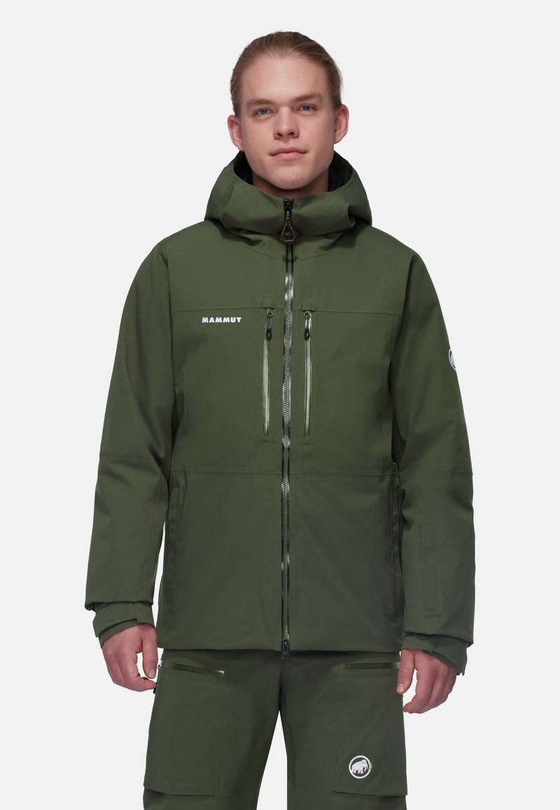 Giacca impermeabile verde con cappuccio, dotata di due tasche sul petto, chiusure con cerniera e un logo sul lato sinistro del petto. Tessuto dalla superficie liscia.
