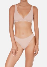 Bralette sans fil rose clair avec un décolleté en V profond et des bretelles fines, associé à un bas de bikini taille haute assorti. Tissu doux et lisse.
