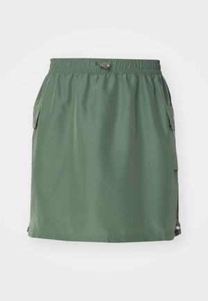 Falda verde caqui hecha de tela ligera, con una cintura elástica, bolsillos laterales y un corte recto con un borde acentuado.