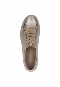 Fémes arany színű sportcipő, lekerekített orral, lapos fűzőkkel és sima textúrával. Az ütőfelületen logó található, valamint fémes díszítések az orr részen.