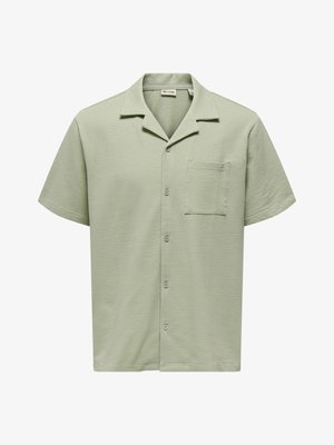 Chemise vert clair à manches courtes avec boutons, tissu texturé, col camp et poche poitrine.