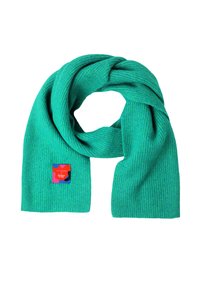 Fular ribbed turcoaz din material moale, având o etichetă roșie și albastră cu marca "TATUUM x Adeline Wong".