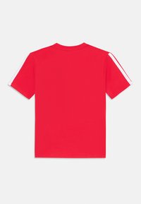 Red short-sleeve t-shirt featuring white stripes along the shoulders, displayed against a plain white background.