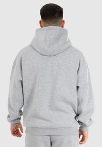Sweat à capuche gris avec une coupe décontractée, grande capuche et poignets et ourlet côtelés. Fabriqué en matière douce avec une texture lisse.
