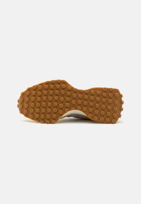Rubber shoe outsole with a textured, dotted pattern; features a white midsole and a soft, neutral-colored upper section.