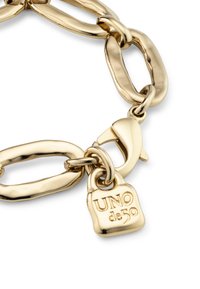 Pulsera de cadena en tono dorado que presenta eslabones ovalados alargados, acabado texturizado y un charm de candado de marca grabado con "UNO de 50."