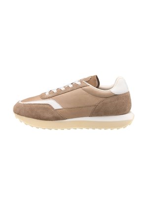 Baskets en suede et cuir marron avec des accents blancs, lacets plats et une semelle extérieure crème texturée, conçues pour un usage décontracté.