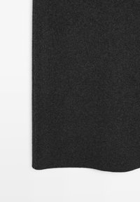 Tessuto grigio scuro lavorato a maglia con trama morbida visibile e orlo leggermente coste su sfondo bianco.