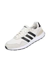 Zapatillas Adidas con parte superior en crema, detalles en ante negro y tres franjas negras, lengüeta de malla texturizada y suela de goma blanca.