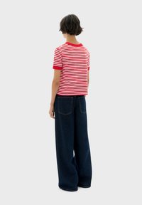 Rood-witte gestreepte short-sleeve shirt met een ronde hals, gecombineerd met hoge taille donkerblauwe wijde jeans.