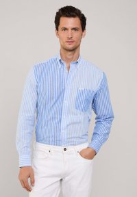 Camicia azzurro chiaro a righe con piccola tasca sul petto, realizzata in tessuto intrecciato, con colletto e chiusura a bottoni.