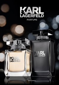 Flacon de parfum en verre clair avec un bouchon carré (liquide clair), à côté d'un flacon en verre noir au design rectangulaire épuré et avec un bouchon similaire.