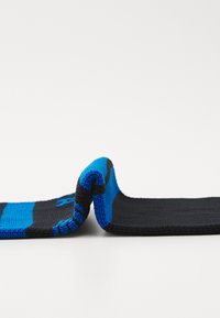 Stickade strumpor med en blandning av svart och blå färger, med ett randigt mönster som framhäver en mjuk textur och en flexibel design.