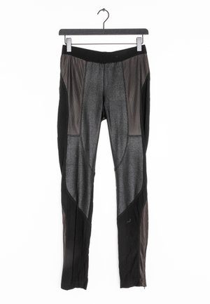 Černé sportovní kalhoty s texturovaným šedým předním dílem, síťovými bočními panely, elastickým pasem a zipy na kotnících. Ploché švy pro pohodlí.