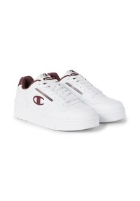 Weiße Sneaker mit burgunderroten Akzenten, aus einem lederähnlichen Material gefertigt. Sie verfügen über eine dicke Sohle, Perforationen für Atmungsaktivität und Schnürsenkel.
