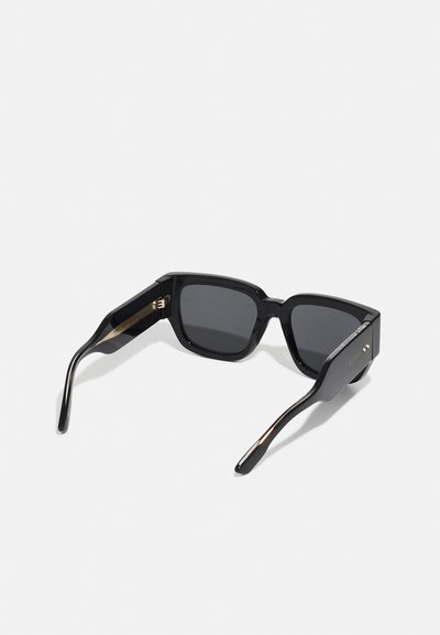 Black square sunglasses with dark lenses, polished plastic frame, gold accents on the temples, and a thick design for a bold appearance.