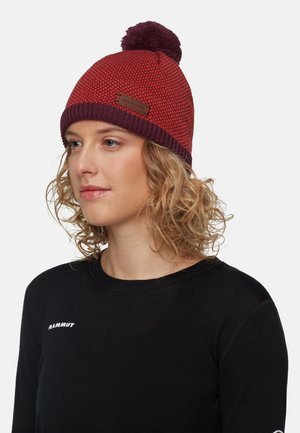 Rode en bordeaux gebreide beanie met een pompon bovenop, voorzien van een leren label. De textuur lijkt dik en gestructureerd, waardoor het geschikt is voor warmte.