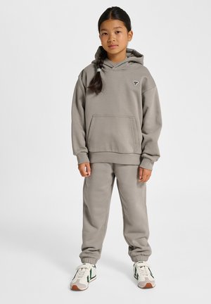 Ensemble sweat à capuche gris et pantalon de survêtement en mélange de coton doux, avec une poche kangourou et des poignets élastiques, porté avec des baskets blanches et vertes.